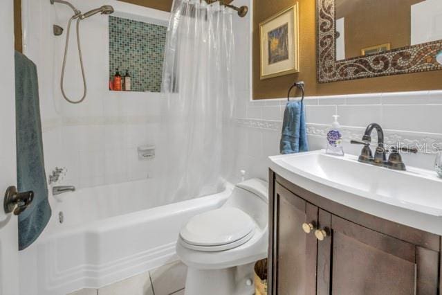 full bathroom featuring toilet, tile walls, vanity, shower / bathtub combination with curtain, and tile patterned flooring