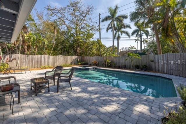 view of swimming pool featuring an in ground hot tub and a patio