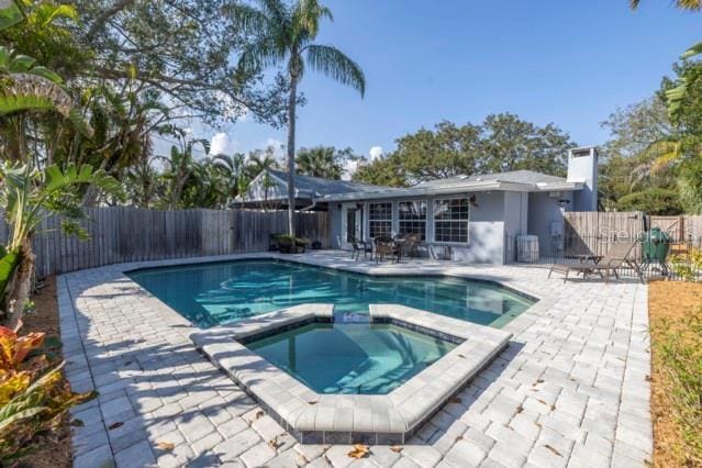 view of swimming pool with an in ground hot tub and a patio area