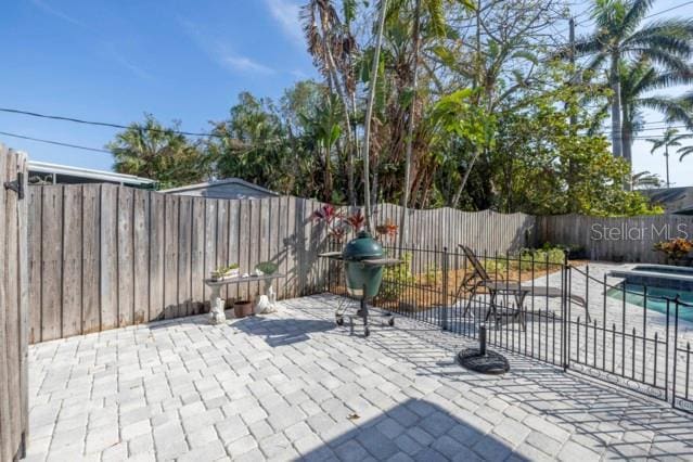 view of patio featuring area for grilling and a fenced in pool