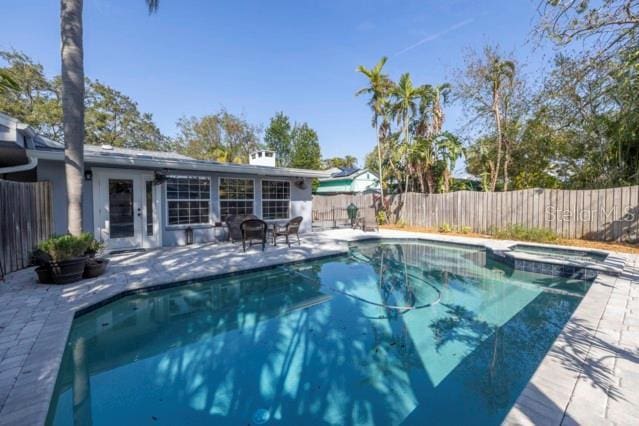 view of swimming pool featuring an in ground hot tub and a patio area