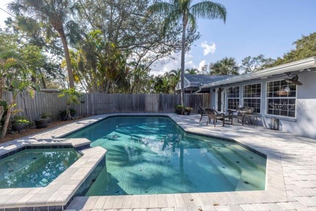 view of swimming pool featuring a patio area and an in ground hot tub