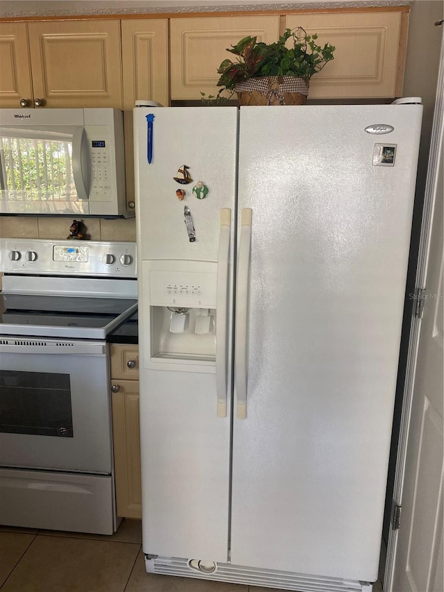 kitchen with light brown cabinets, tile patterned floors, and white appliances