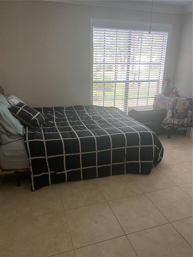 tiled bedroom featuring crown molding