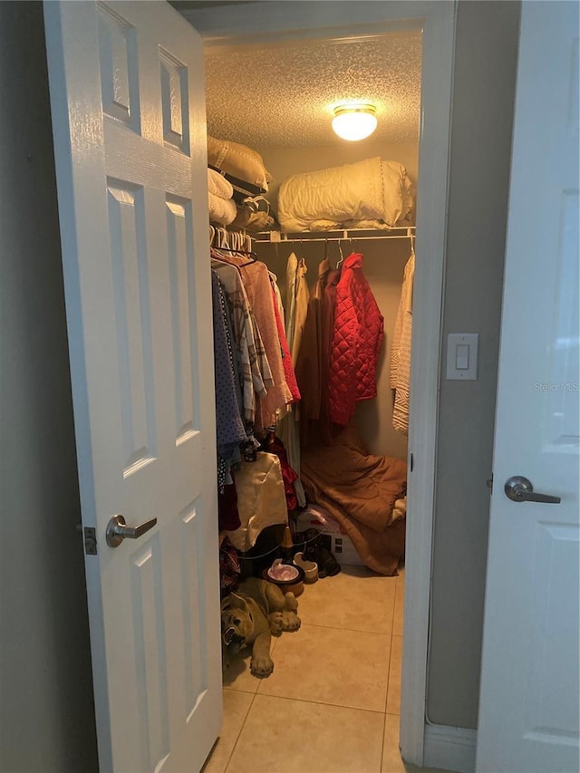 walk in closet with light tile patterned floors