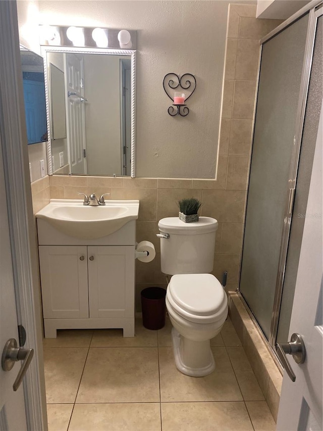 bathroom featuring tile patterned flooring, vanity, tile walls, and toilet