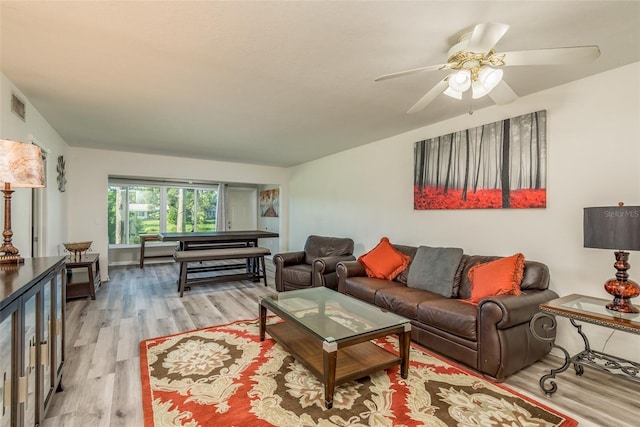 living room with ceiling fan and light hardwood / wood-style flooring