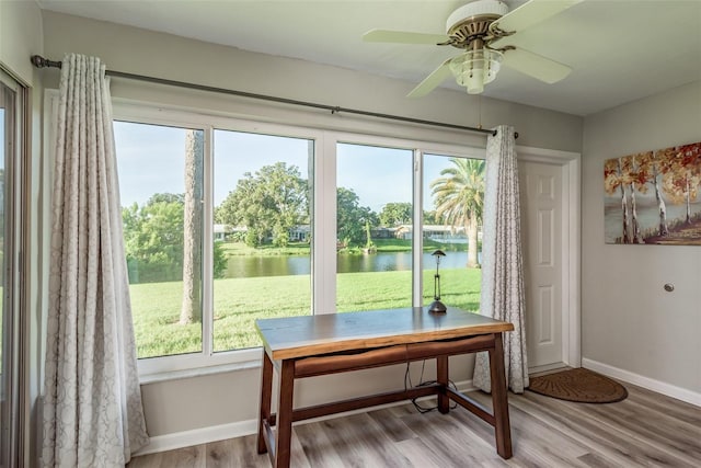 doorway to outside with a water view, ceiling fan, and light hardwood / wood-style flooring