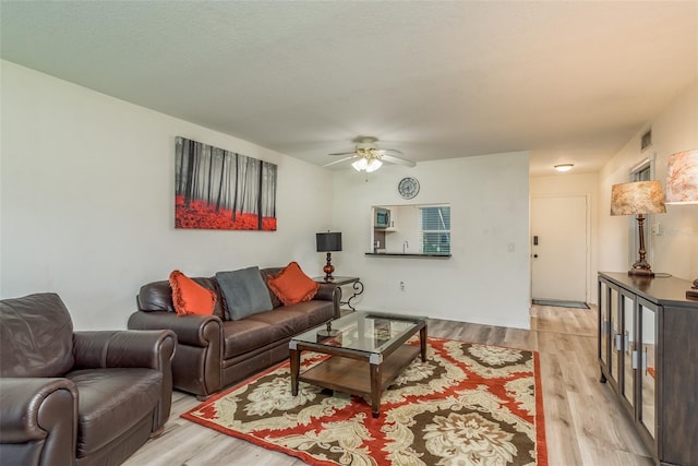 living room featuring ceiling fan and light hardwood / wood-style flooring