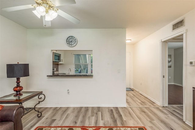 interior space with sink, light hardwood / wood-style flooring, and ceiling fan