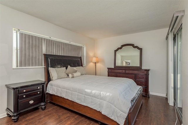 bedroom featuring dark wood-type flooring and a textured ceiling