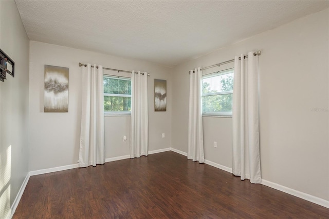 unfurnished room with dark hardwood / wood-style floors and a textured ceiling