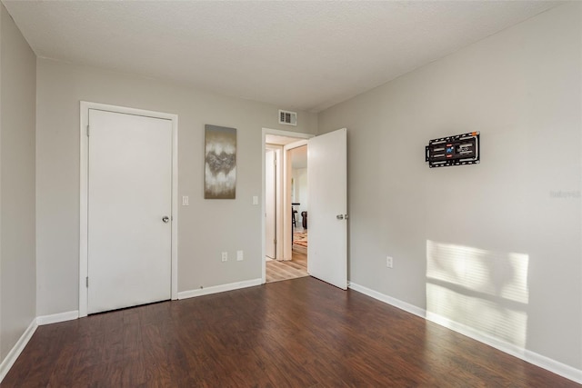 unfurnished bedroom featuring hardwood / wood-style floors and a textured ceiling