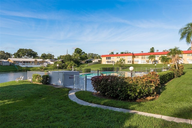 view of pool featuring a water view and a lawn