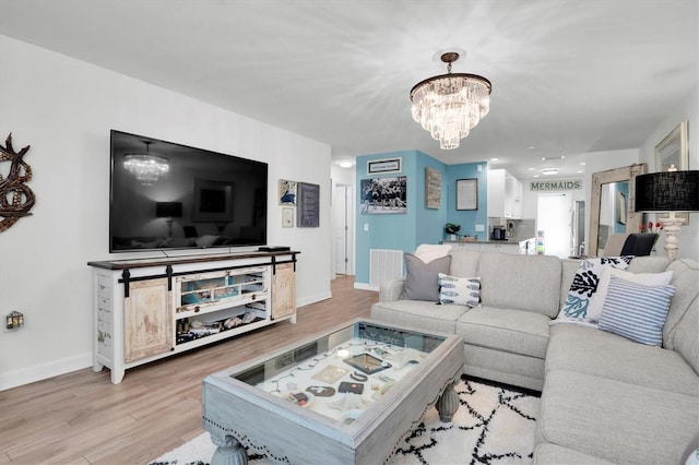 living room with a notable chandelier and light hardwood / wood-style floors
