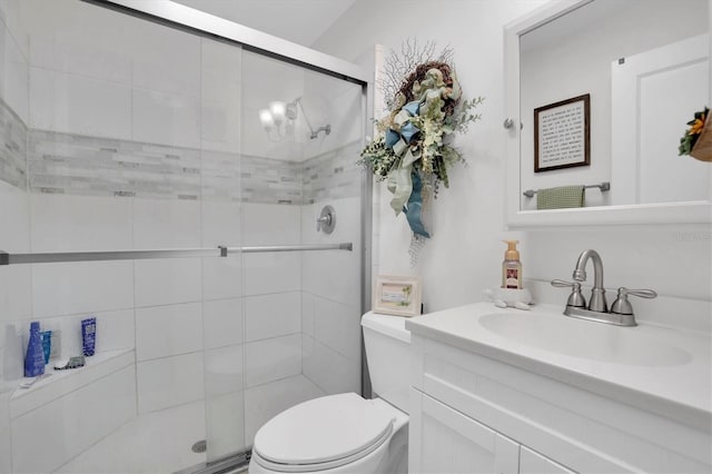 bathroom with vanity, a shower with door, and toilet