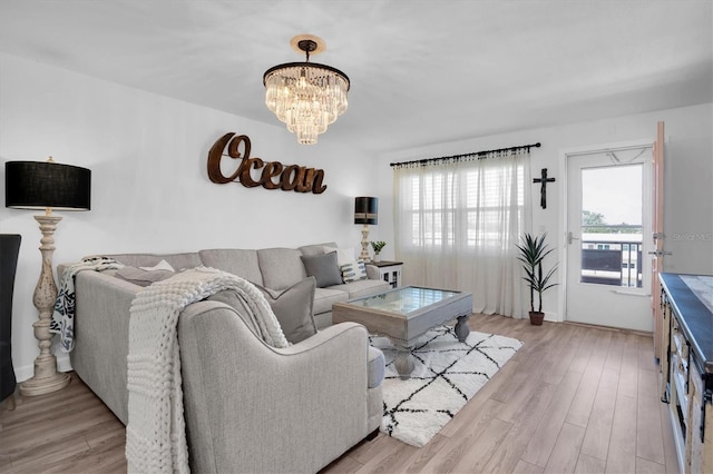 living room with an inviting chandelier and light hardwood / wood-style floors