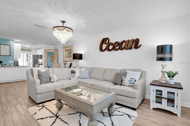 living room featuring light hardwood / wood-style flooring and a notable chandelier