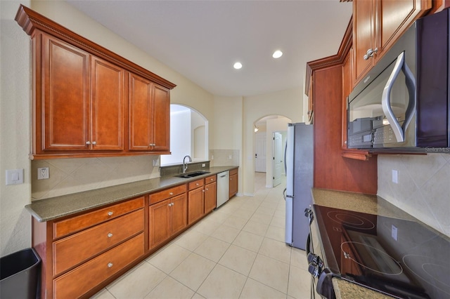 kitchen featuring sink, backsplash, stainless steel appliances, and light tile patterned floors