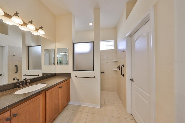 bathroom featuring tile patterned flooring, vanity, and tiled shower