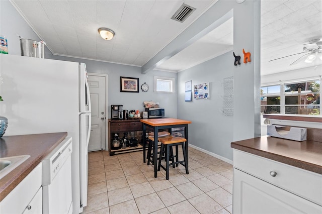 dining space featuring crown molding, ceiling fan, and light tile patterned flooring