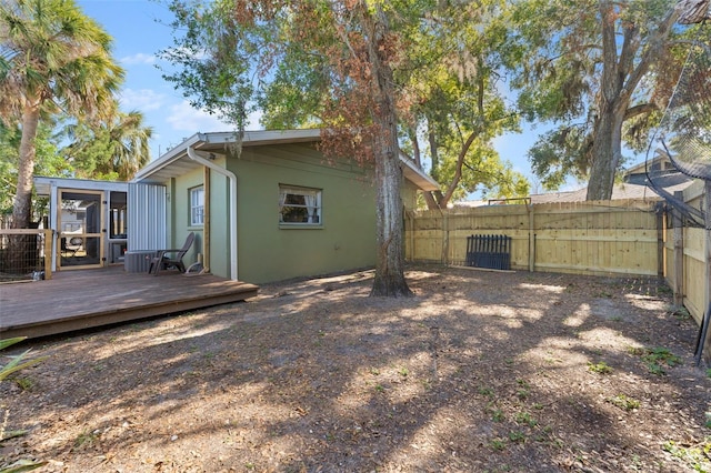 back of house with a wooden deck and a sunroom