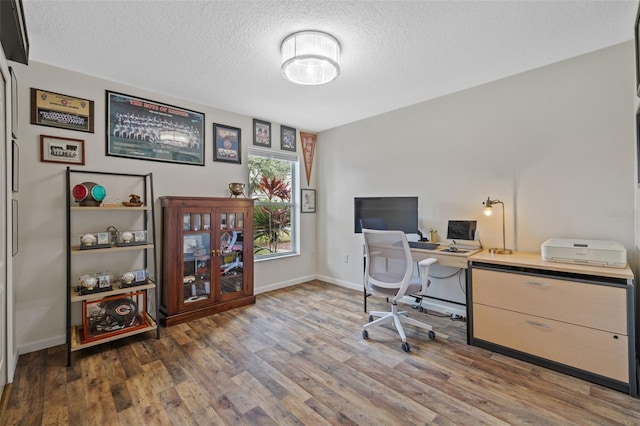 home office featuring a textured ceiling and dark hardwood / wood-style flooring