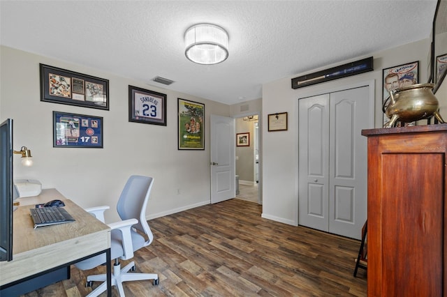 home office with dark wood-type flooring and a textured ceiling