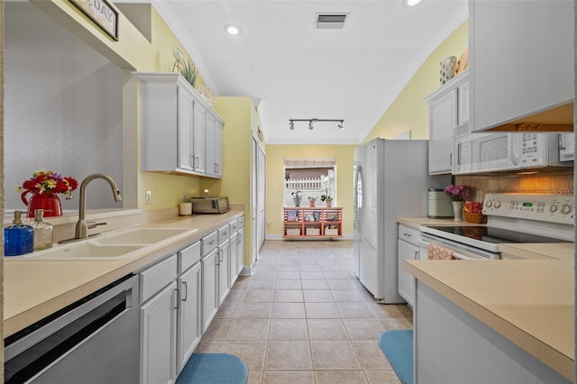 kitchen with white cabinetry, sink, light tile patterned floors, and white appliances