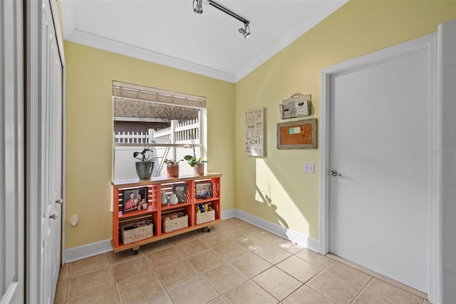 hall featuring light tile patterned floors, ornamental molding, and rail lighting