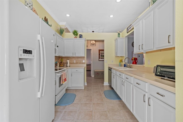 kitchen with sink, white cabinets, decorative backsplash, light tile patterned floors, and white appliances