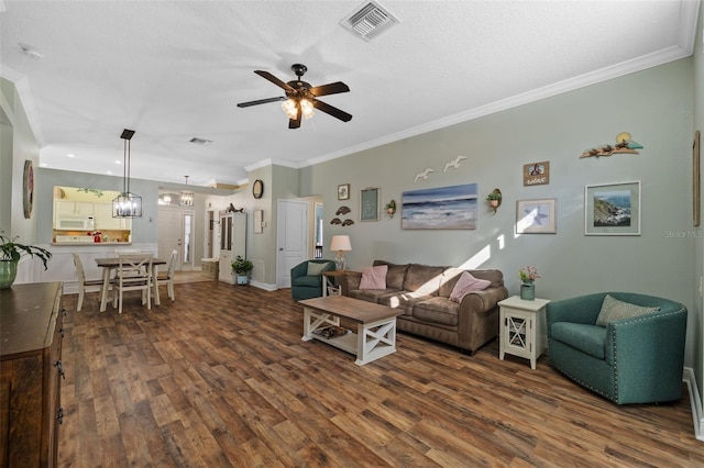 living room with ceiling fan, crown molding, a textured ceiling, and dark hardwood / wood-style flooring