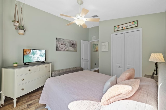 bedroom featuring light hardwood / wood-style flooring, vaulted ceiling, a closet, and ceiling fan