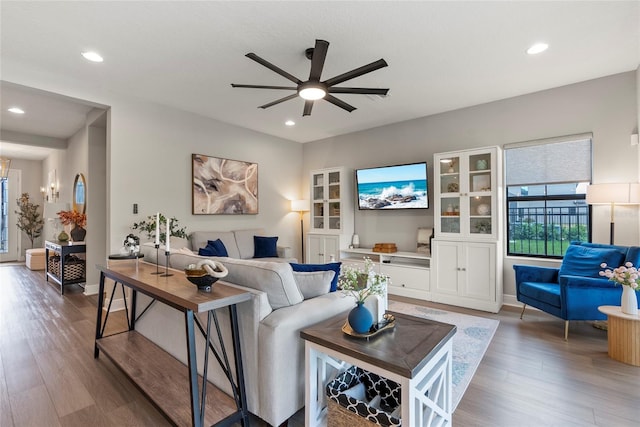 living room with wood-type flooring and ceiling fan