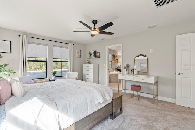 carpeted bedroom featuring ceiling fan and ensuite bath