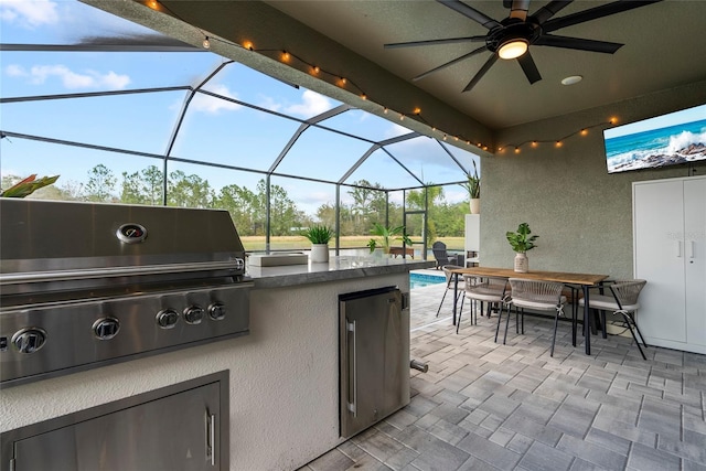 view of patio / terrace with a grill, glass enclosure, and exterior kitchen