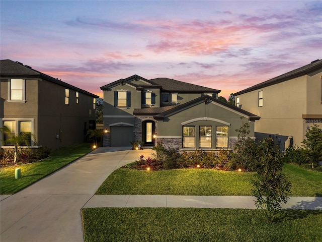 view of front of house with a garage and a yard