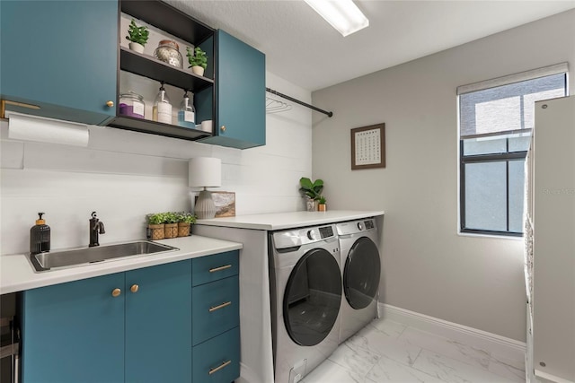 laundry area featuring cabinets, sink, washing machine and dryer, and a textured ceiling