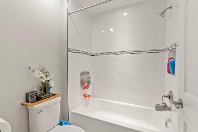 bathroom featuring toilet and tiled shower / bath combo