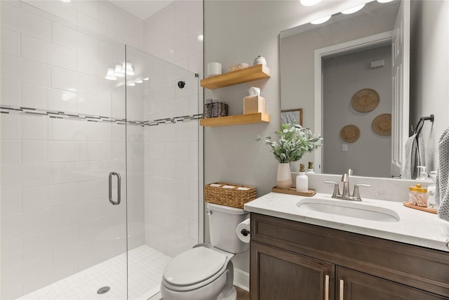 bathroom featuring a shower with door, vanity, and toilet