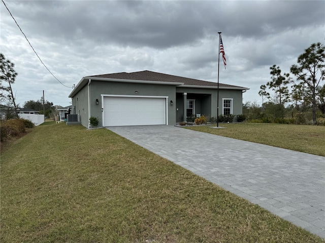 view of front of home featuring a garage, a front yard, and central air condition unit