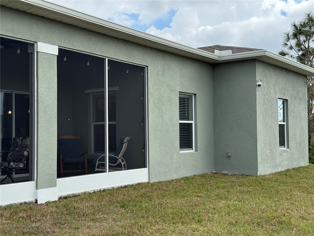 view of side of home with a sunroom and a yard