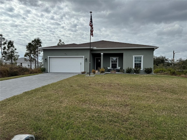493 Omen St, Punta Gorda, FL 33982 - view of front of home featuring stucco siding, decorative driveway, an attached garage, and a front yard