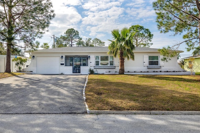 ranch-style home featuring a garage and a front lawn