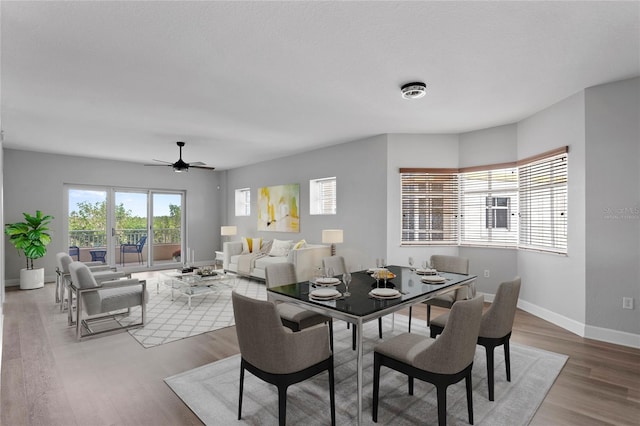 dining area with wood-type flooring and ceiling fan