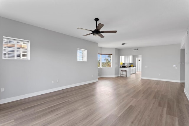 unfurnished living room with ceiling fan and light hardwood / wood-style floors