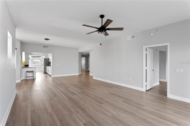 unfurnished living room with light hardwood / wood-style flooring and ceiling fan