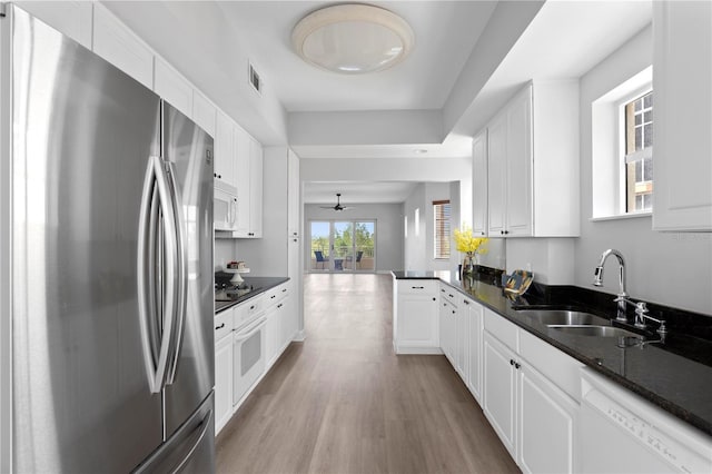 kitchen with sink, white cabinets, white appliances, and light hardwood / wood-style flooring