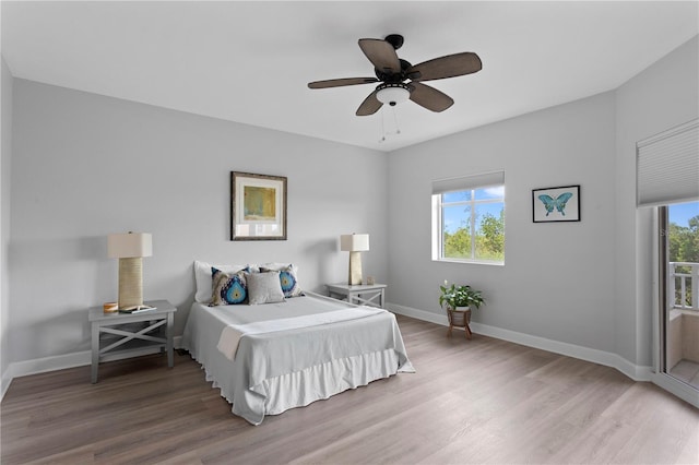 bedroom featuring multiple windows, hardwood / wood-style flooring, and ceiling fan