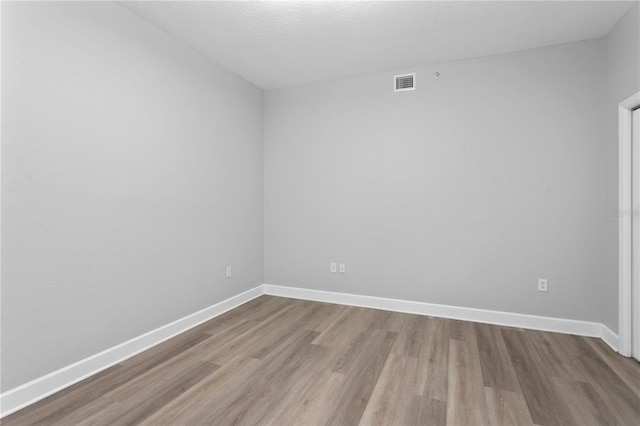 empty room featuring light hardwood / wood-style flooring and a textured ceiling